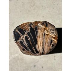 a piece of rock sitting on top of a cement floor next to a black and white object