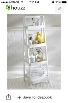 a white bathroom shelf with towels and other items