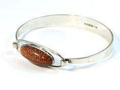 Vintage silver bracelet with Goldstone, designed by Erik Granit, Helsinki Finland 1961. The bracelet is 60mm x 52mm and the top part is 38mm x 14mm. The Goldstone is placed in the middle of the top part and is 25mm x 10mm. Hallmarks: E.Granit & Co / Manufacturer Mark  Crown in Heart / Finland National Mark  813H / Silver Purity Mark  Boat / Helsinki City Mark  H7 / Finland Year Mark 1961 Please feel free to contact us for any further information. Free shipment worldwide. Upgrades are available on check out. The bracelet will be safely packed and shipped within one to three business days. Thank you for visiting NordicLightsJewels and we hope to welcome you soon again! Helsinki Finland, Bracelet Vintage, Artistic Jewelry, Helsinki, Arm Band, Vintage Silver, Finland, Cuff Bracelets, Silver Ring