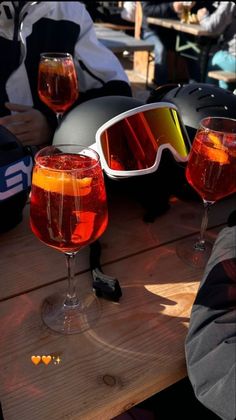 two wine glasses and goggles sitting on a table