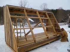 a man working on a wooden structure in the snow