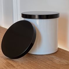 a white and black container sitting on top of a wooden floor