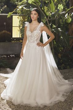 a woman in a wedding dress posing for the camera with her hands on her hips