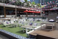 an outdoor seating area with tables and umbrellas in front of a large city building