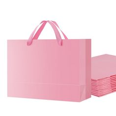 pink paper bags stacked on top of each other in front of a white background,