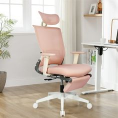 a pink office chair sitting on top of a hard wood floor next to a window