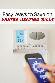 a person holding a cell phone in front of an appliance with the text easy ways to save on winter heating bills