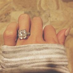 a woman's hand with a diamond ring on it