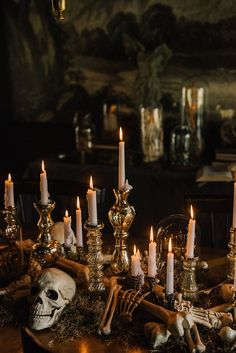 a table topped with lots of candles and skulls