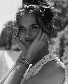 black and white photograph of a woman with her hands on her face, smiling at the camera