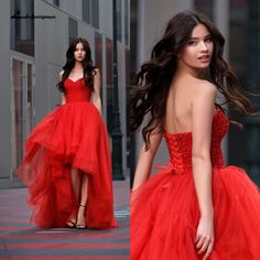 a woman in a red dress is walking down the street