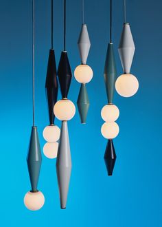 a group of lights hanging from a ceiling next to each other on a blue wall