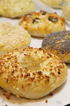 there are many different types of bagels on the tray, including one with poppy seed sprinkles