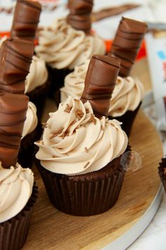 chocolate cupcakes with white frosting on a wooden platter