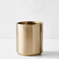 a gold metal cup sitting on top of a white table