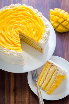 there is a cake with yellow frosting on the plate and one slice has been cut