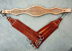 a brown leather belt with chains attached to it on the concrete floor next to a pair of scissors