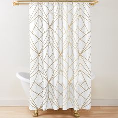 a white shower curtain with gold lines on it and a bathtub in the background