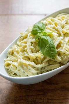 pasta in a white dish with basil on top