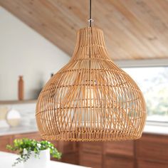 a bamboo light fixture hanging from a ceiling in a kitchen with white counter tops and wooden cabinets