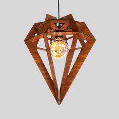 a wooden light hanging from the ceiling with a glass bulb in it's center