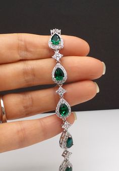 genuine Swarovski emerald green foiled back teardrop crystal rhinestone in the cubic zirconia decorated teardrop white gold rhodium plated settings. **Available in different color stone. Please inquire.** Size: 6.5, 7 or 7.5 inches Matching necklace and earrings available and sold separately. https://www.etsy.com/listing/228084487/wedding-jewelry-bridal-bridesmaid?ref=listings_manager_grid https://www.etsy.com/listing/180038564/wedding-bridal-jewelry-bridesmaid-gift?ref=listings_manager_grid htt Elegant Jewelry With Handset Stones For Gift, Elegant Jewelry With Handset Stones As A Gift, Elegant Drop Jewelry With May Birthstone, Elegant Drop Jewelry For May Birthstone, Elegant Pear-shaped Emerald Jewelry, Green Emerald Bracelets For Party, Elegant Crystal Bracelet With Handset Stones For Gift, Cubic Zirconia Crystal Bracelet For Wedding, Cubic Zirconia Gemstone Bracelet For Wedding