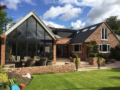 a large brick house sitting on top of a lush green field