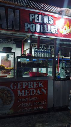 a person standing in front of a food stand at night