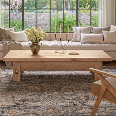 a living room with couches, tables and chairs in front of a large window