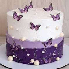 a white and purple cake with butterflies on it