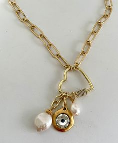 This lovely necklace is an adjustable paper clip chain featuring a heart carabiner clasp with freshwater pearls and a Swarovski crystal focal.  I have made the chain adjustable to give you more options to get the perfect length for your outfit.  The chain is high quality brass electro plated with 18kt gold, so it will not tarnish.   I used beautiful natural pearls and a gorgeous crystal charm.  The length is adjustable up to 20 inches. All materials are free of lead, nickel, or cadmium.  We suggest you apply hairspray and perfume before putting on your jewelry.  You should avoid salt water, pool chemicals or any harsh chemicals. Heart Carabiner, Pave Heart Necklace, Necklace Heart, Charm Necklaces, Lovely Necklace, Trombone, Crystal Charm, Heart Pendant Necklace, Natural Pearls