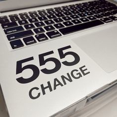 an open laptop computer sitting on top of a white table with the word 555 change printed on it