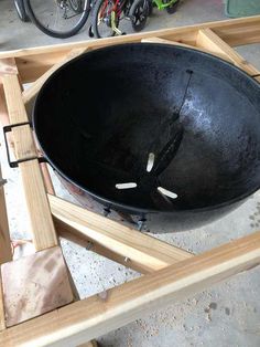 a large black bowl sitting on top of a wooden table