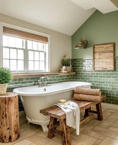 a white bath tub sitting under a window next to a wooden bench in a bathroom