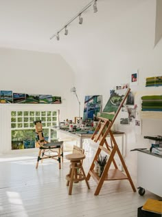 an artist's studio with easels and paintings on the wall