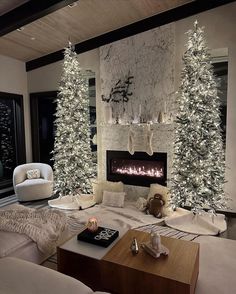 a living room decorated for christmas with white trees and lights on the fireplace mantel