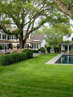 a large house with a pool in the middle of it and lots of grass on the ground