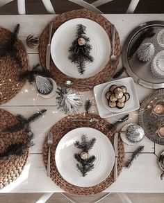 the table is set with silverware and pine cones