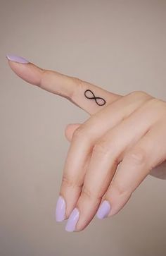 a woman's hand with a small tattoo on it