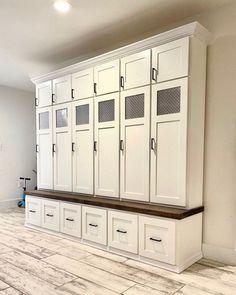 an empty room with white cabinets and drawers