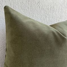 a green pillow sitting on top of a white wall