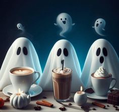 three white ghost figures with hot chocolate and marshmallows on a table next to a cup of coffee