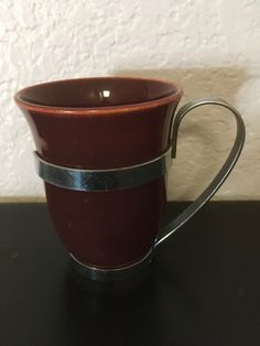 a brown coffee cup sitting on top of a black table