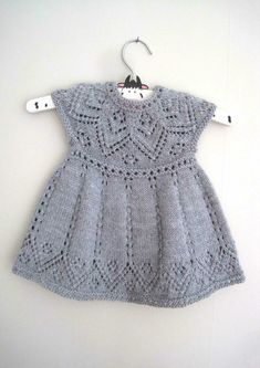 a gray dress is hanging on a white hanger and it has an openwork design