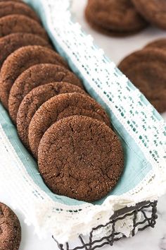 chocolate cookies are arranged in a row on a lace doily next to other cookies