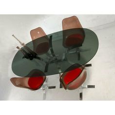 a glass table with four chairs around it and one chair on the other side,