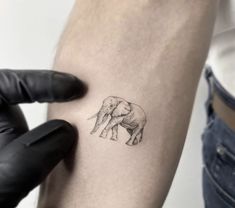 a small elephant tattoo on the arm