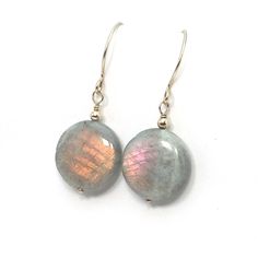 The gorgeous flashy Labradorite coins give off beautiful flashes of reds, golds, greens, and/or blues. These lovely stones are complemented with sparkling Gold Filled or Sterling Silver components (you choose).  According to an old Inuit story, a wandering Inuit warrior found the Northern Lights imprisoned in stones along the coast of Labrador. He was able to free most of the lights with a mighty blow of his spear, which are now seen at night in the Northern skies. Some of the lights were still Iridescent Labradorite Jewelry With Natural Stones, Iridescent Round Gemstone Jewelry, Iridescent Gemstone Jewelry, Nickel-free Iridescent Round Earrings, Handmade Iridescent Round Jewelry, Adjustable Round Labradorite Earrings, Iridescent Round Jewelry With Ear Wire, Power Stone, Coin Earrings