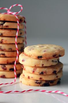 a stack of cookies sitting next to a red and white twine on top of a table