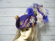 One-of-a-kind PURPLE NOT BLUE woolen pirate hat with golden venise lace, purple pleated trim and matching braid. Purple not blue and beige ostrich feathers, two black and gold feathers tucked in, a 4" sparkly crowned rhinestone skull accent and two satin bows. Perfect for any pirate event. Please measure your head as I cannot make this hat bigger. This hat is 22.5" for the inside circumference with a built-in hat sizer. Just cinch and tie. This is not an oversized brim pirate hat. The upturn brim is about 4". International buyers are responsible for custom fees as it is not included in the shipping. Please Click on the shipping tab to calculate shipping so there are no surprises over shipping.    ALL SALES ARE FINAL!!! NO EXCHANGES! NO REFUNDS! ASK QUESTIONS AHEAD OF TIME AS ALL SALES ARE Purple Pirate, Hats With Feathers, Rhinestone Skull, Pirate Hat, Steampunk Hat, Ladies Hats, Pirate Hats, Gold Feathers, Jack Sparrow